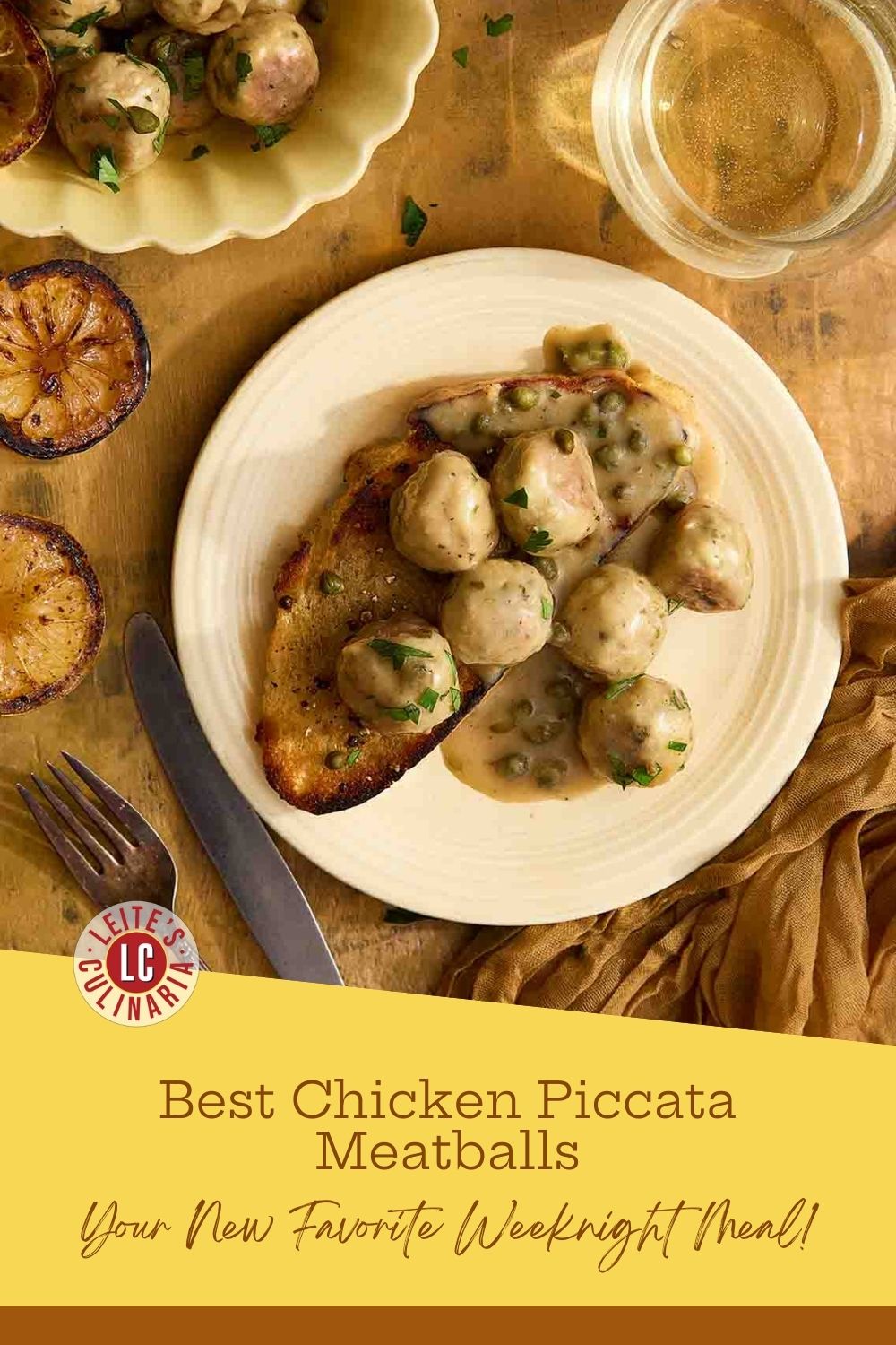 Plate of chicken piccata meatballs in golden sauce on sourdough, with charred lemons nearby.