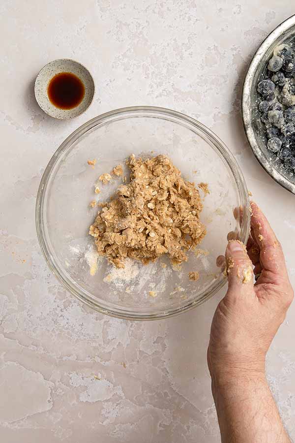 A bowl of fully mixed crumble topping for blueberries.