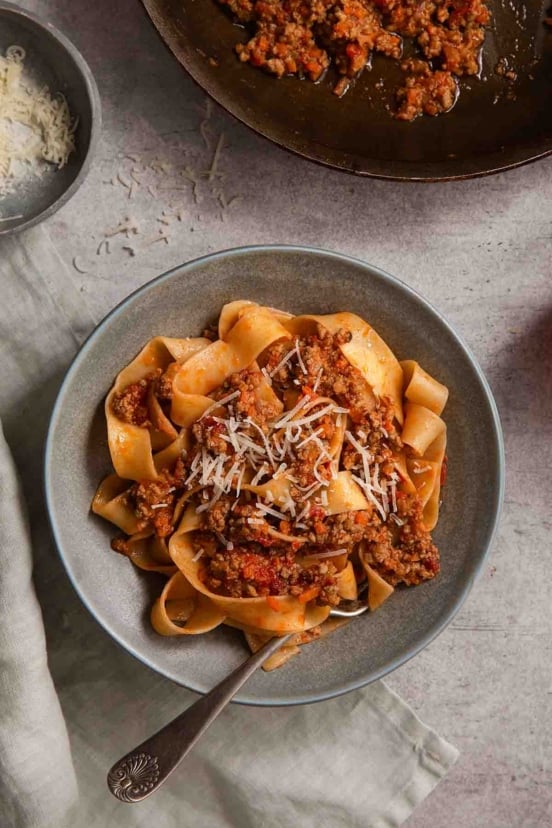 A close-up of tender tagliatelle pasta coated in rich Marcella Hazan Bolognese sauce.