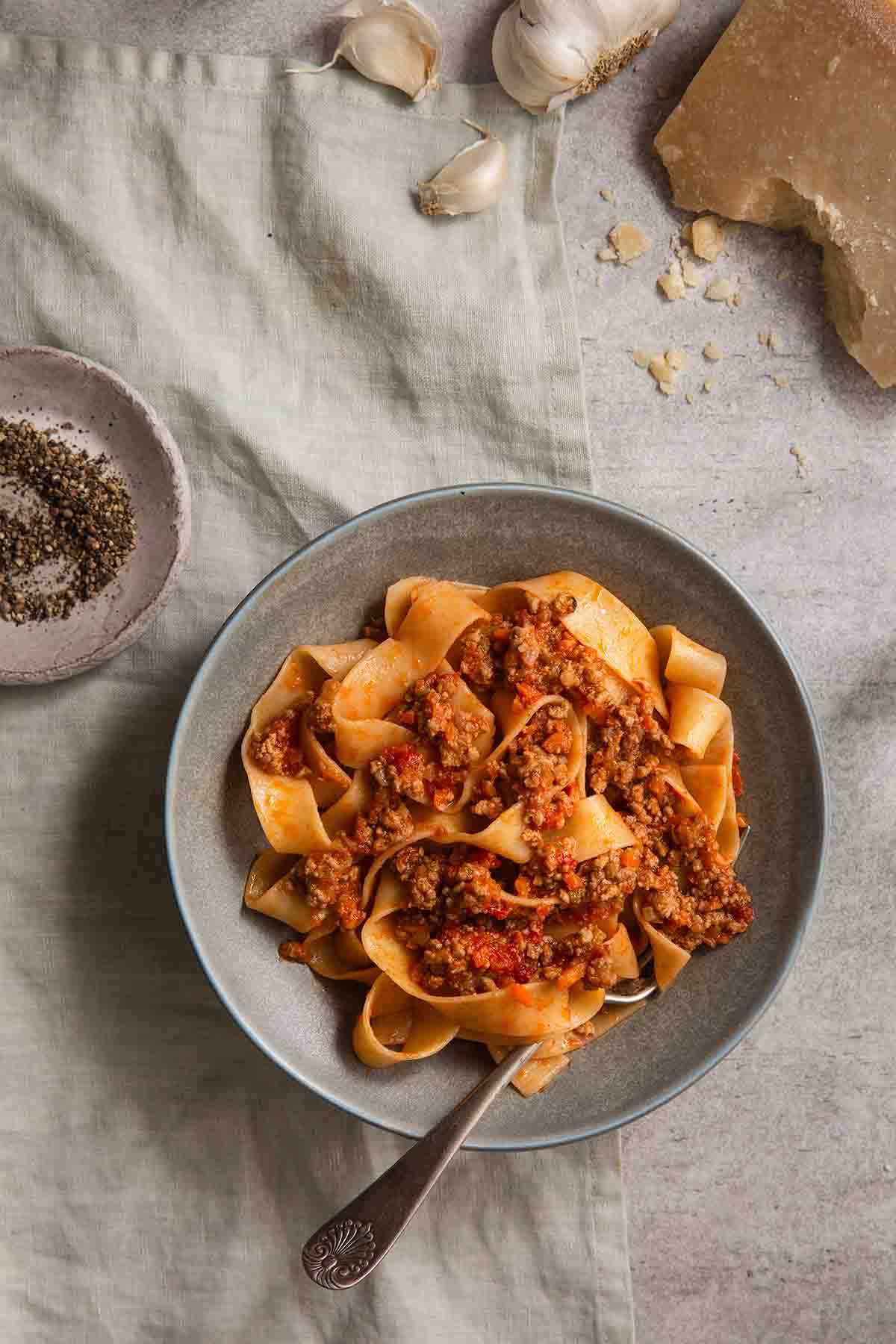 The rich, simmering Marcella Hazan Bolognese sauce with visible meat and vegetables in a Dutch oven.