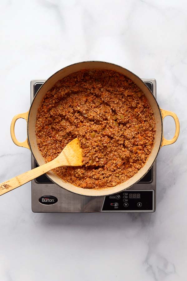 he Bolognese sauce gently simmering uncovered in a Dutch oven, reducing and thickening.