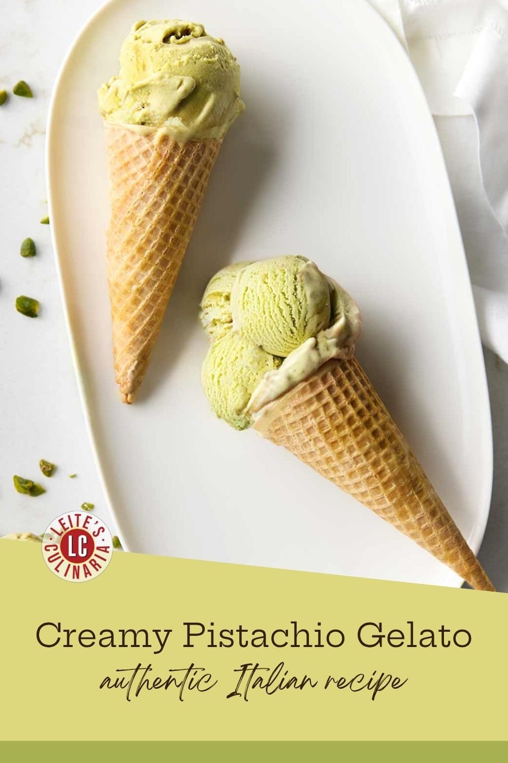 Waffle cones with scoops of authentic Italian pistachio gelato on a white plate with pistachio pieces.