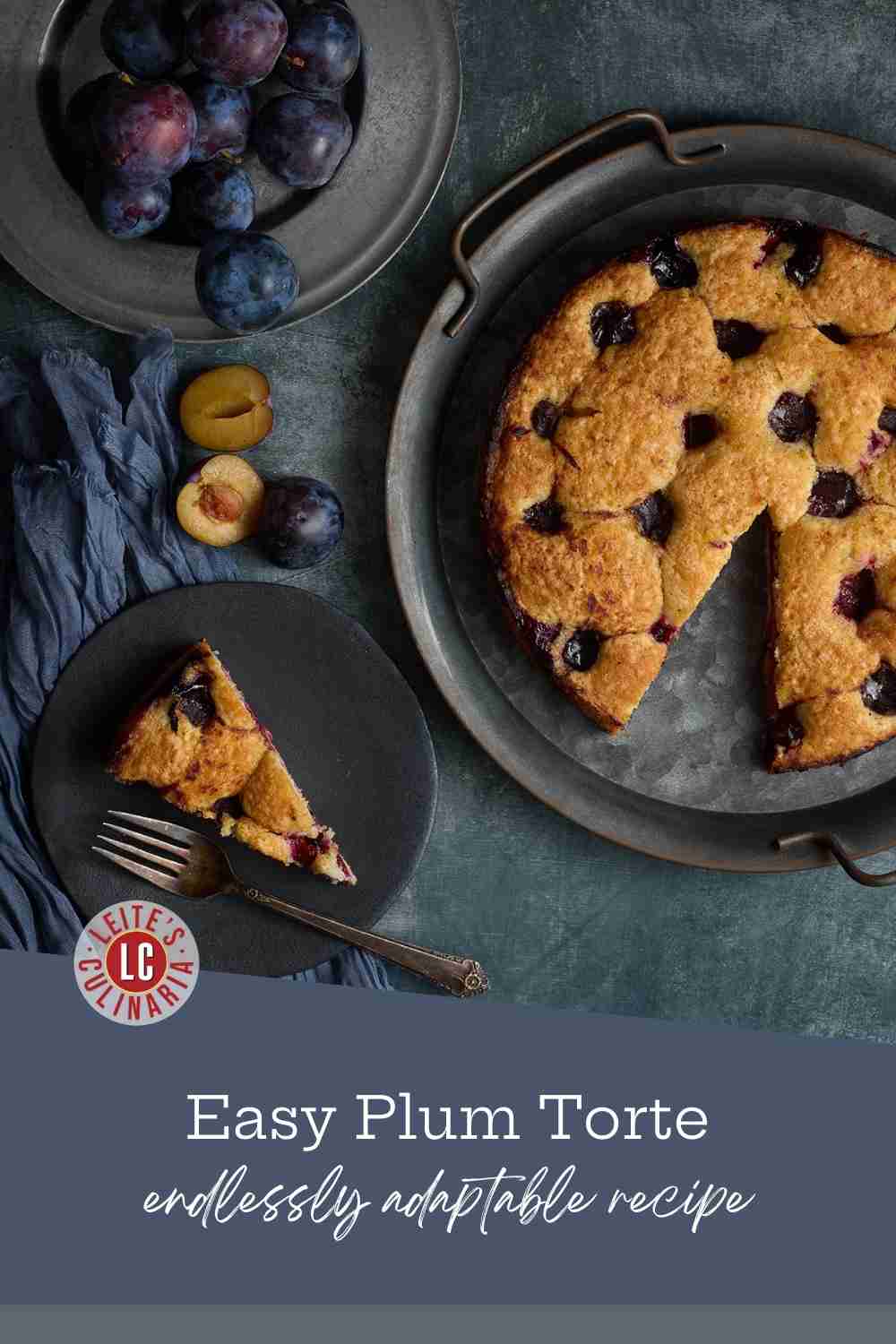A plum tart with a slice taken out; nearby are a plate of plums, and a slice on a plate.