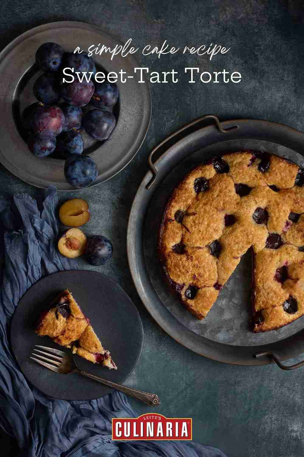 A plum cake on a platter, a slice on a plate, and a pewter plate with fruit.