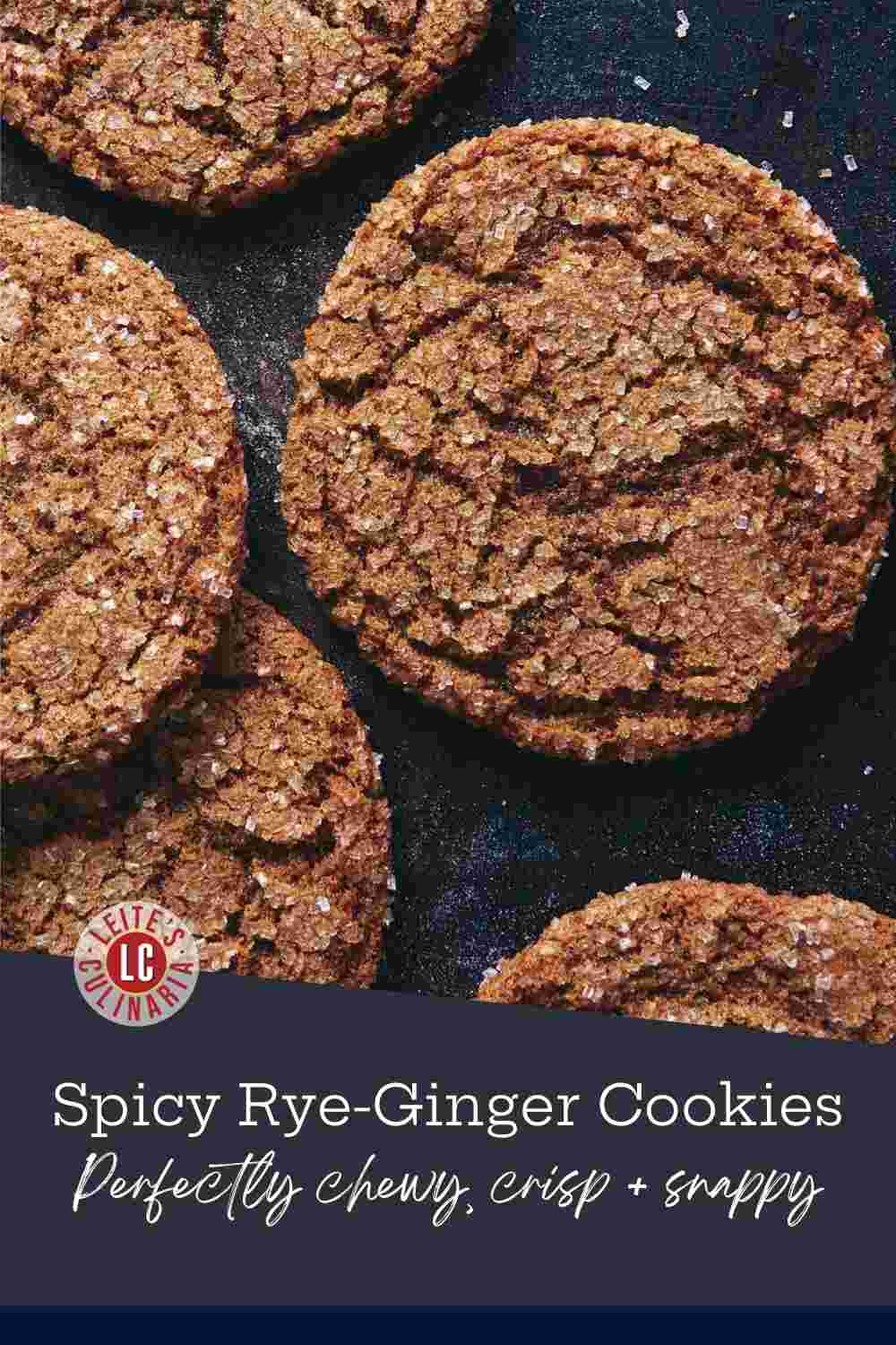 Chewy rye ginger cookies with a crackled, sparkling sugar top arranged on a dark baking sheet.