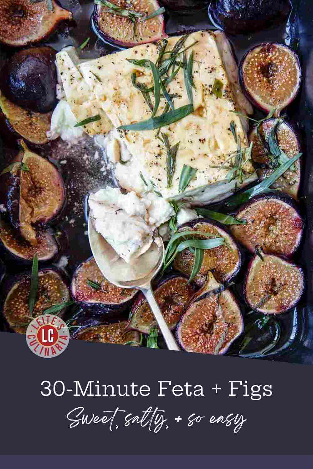 Block of baked feta cheese melting in a black dish, surrounded by roasted fig halves and fresh tarragon.