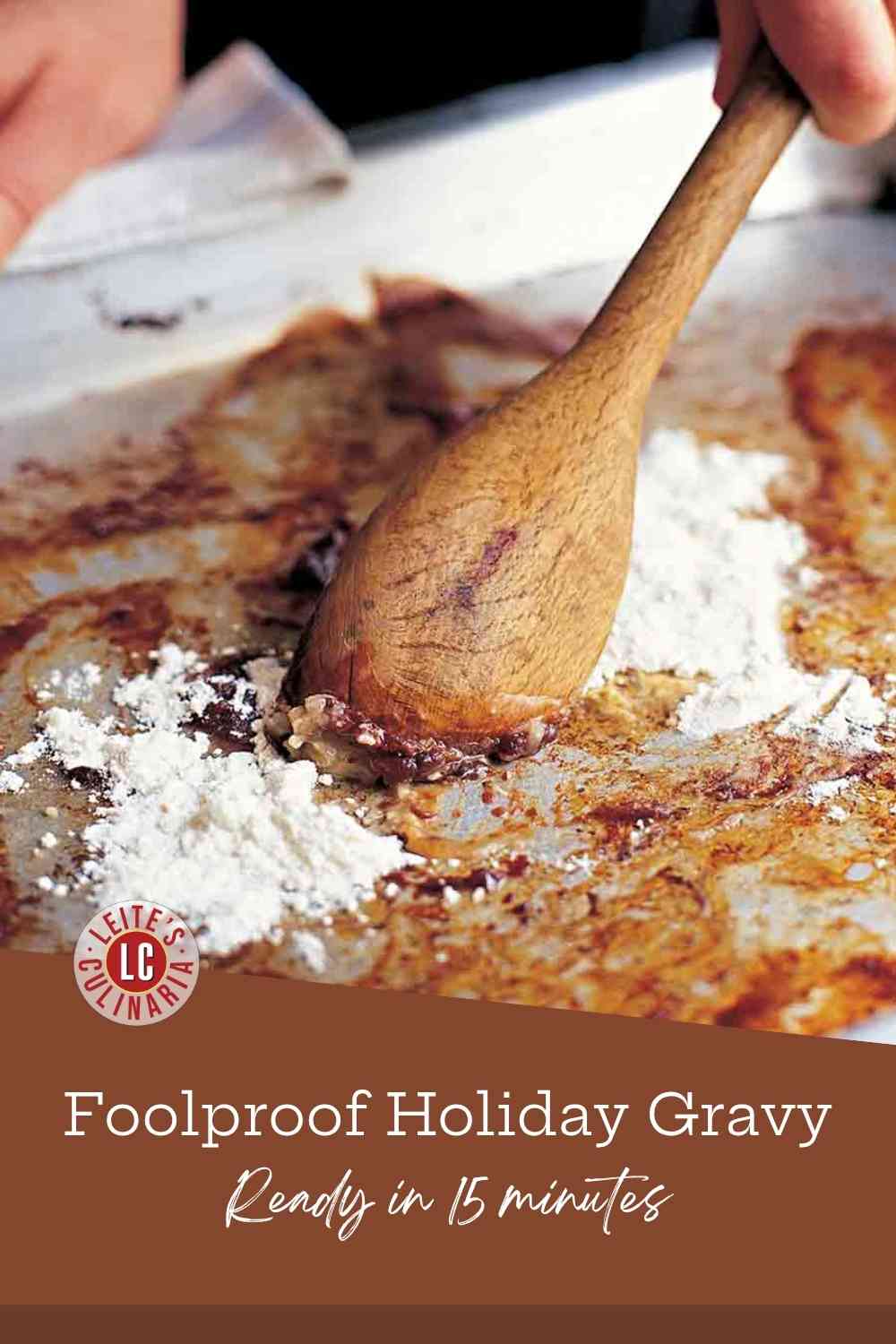 A hand stirring a wooden spoon to blend white flour into dark brown, savory meat drippings and fat on a metal roasting pan.