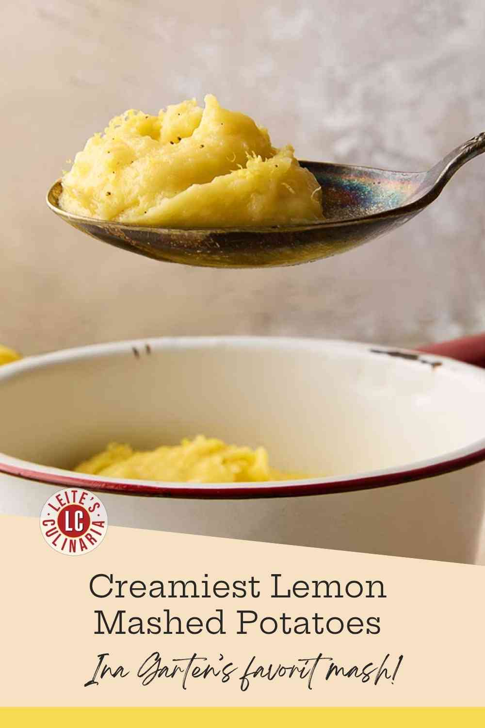 A white enamel pot filled with rich, creamy mashed potatoes, topped with fresh black pepper and bright lemon zest.