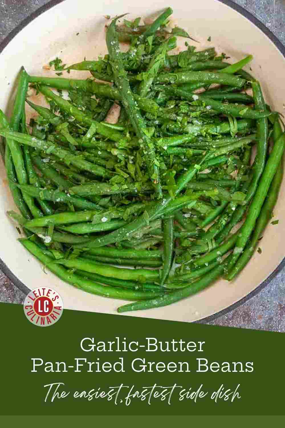 Pan-fried haricots verts tossed in garlic butter and sprinkled with sea salt in a skillet.