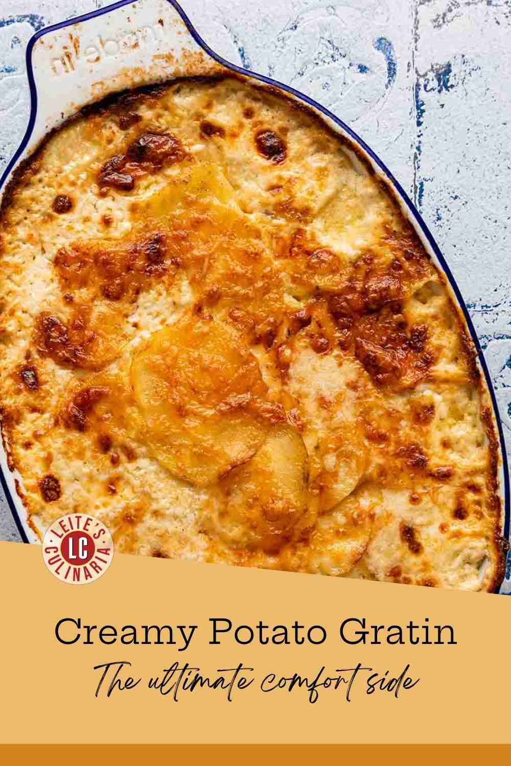 Spoon scooping tender, sliced Yukon Gold potatoes in a garlic-cream sauce from an oval casserole dish.