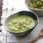 Pumpkin seed mole verde in a bowl, garnished with pumpkin seeds.