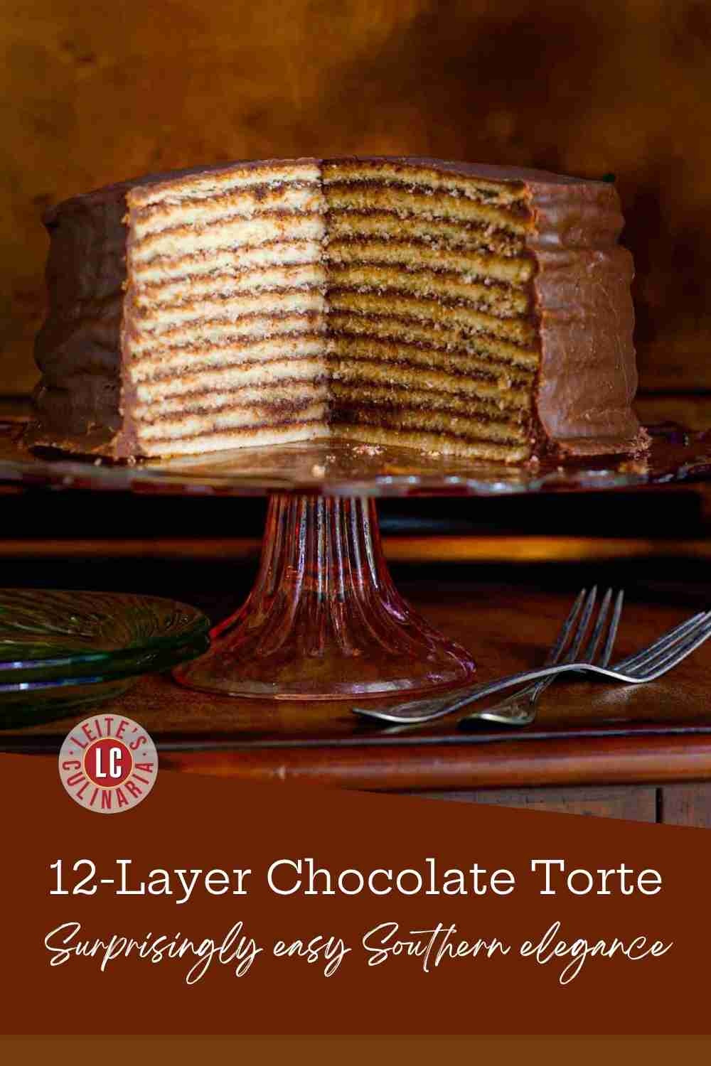 A 12-layer vanilla cake with rich, hardened chocolate glaze on a cake stand.