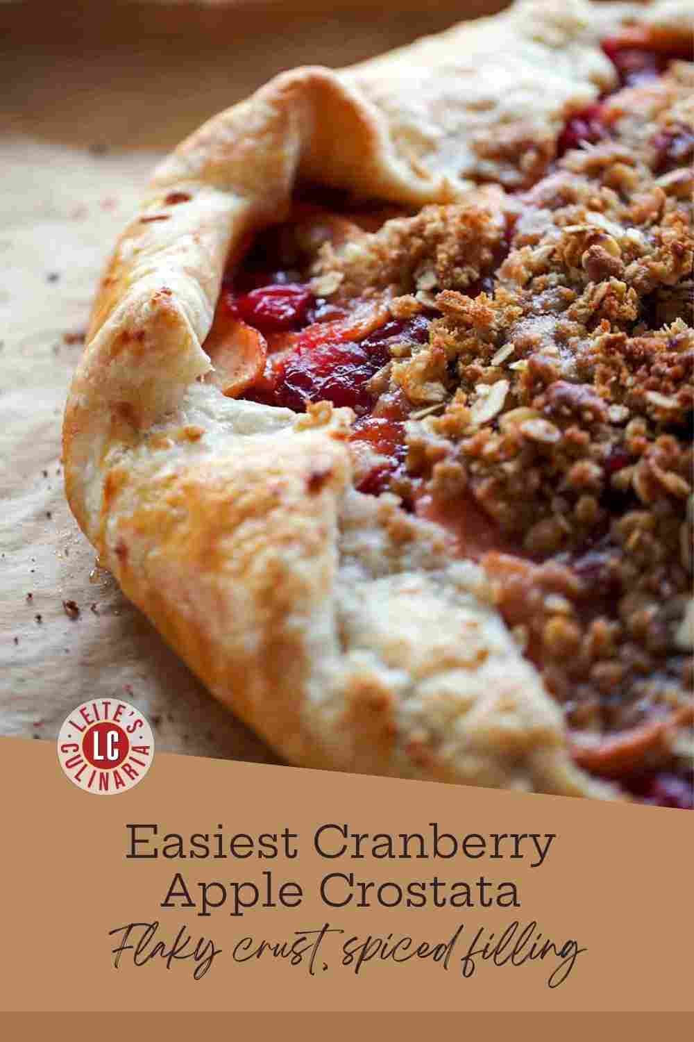 A close-up view of a baked cranberry apple crostata with a golden, flaky crust and a crunchy oatmeal streusel topping.