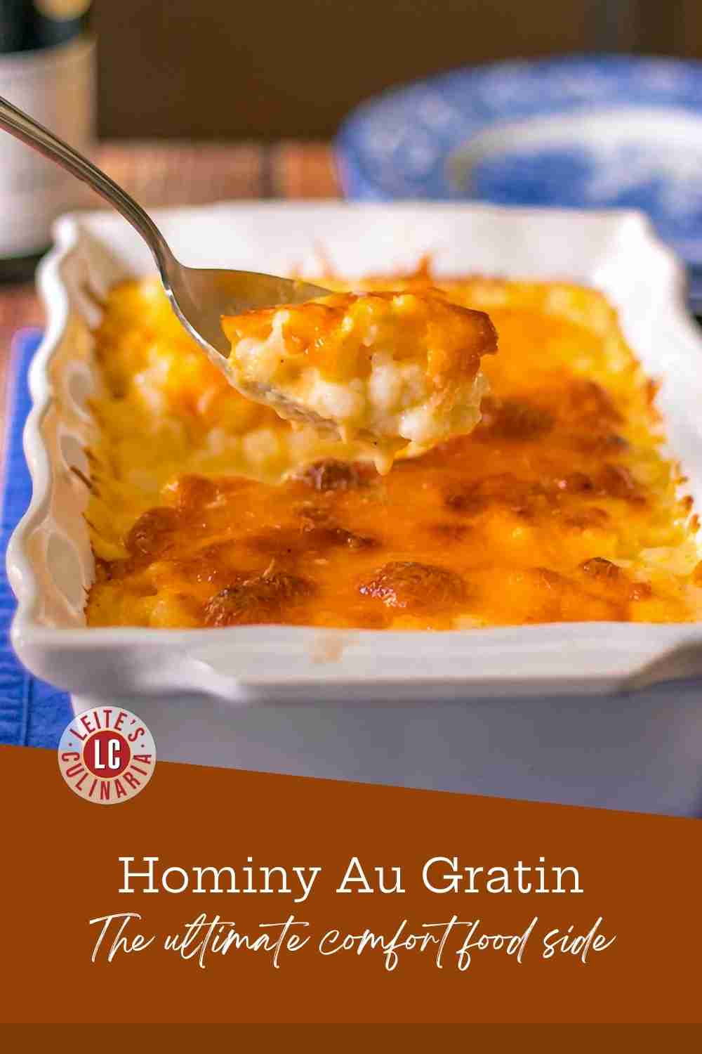 Close-up of hominy au gratin bubbling in a white baking dish, topped with melted cheese and fresh parsley.