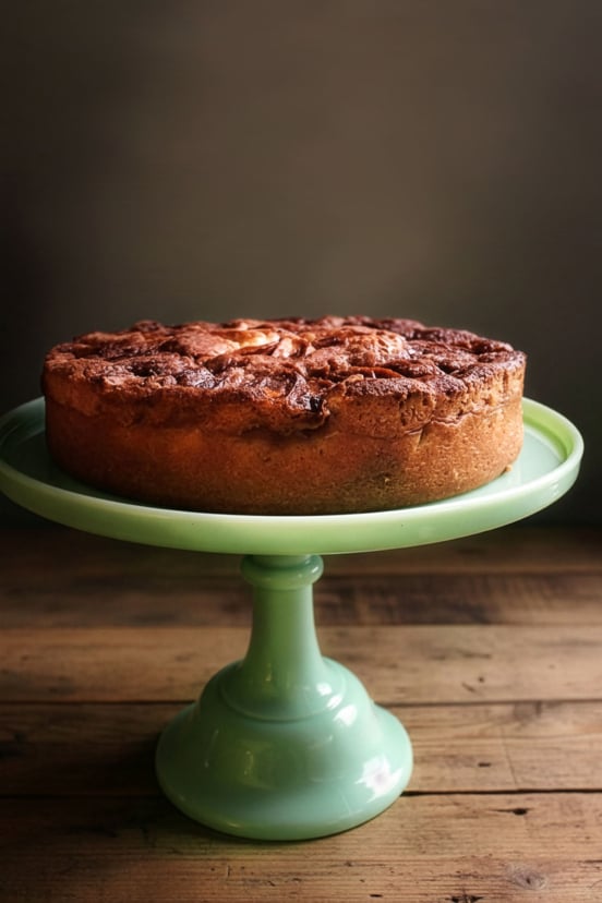 A super moist apple cake on a cake stand.