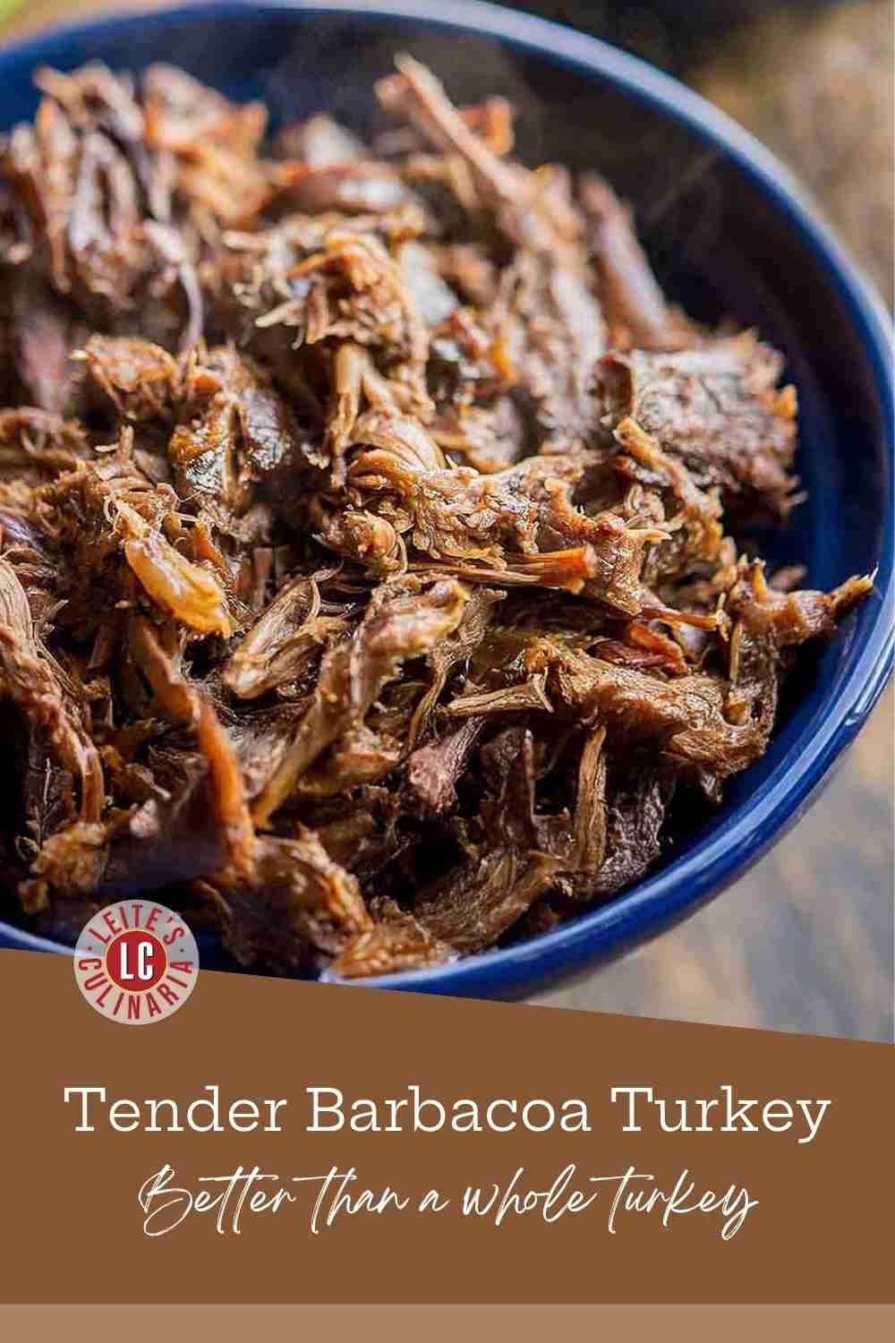 Close-up of smoky, shredded turkey barbacoa covered in a rich red chile sauce.