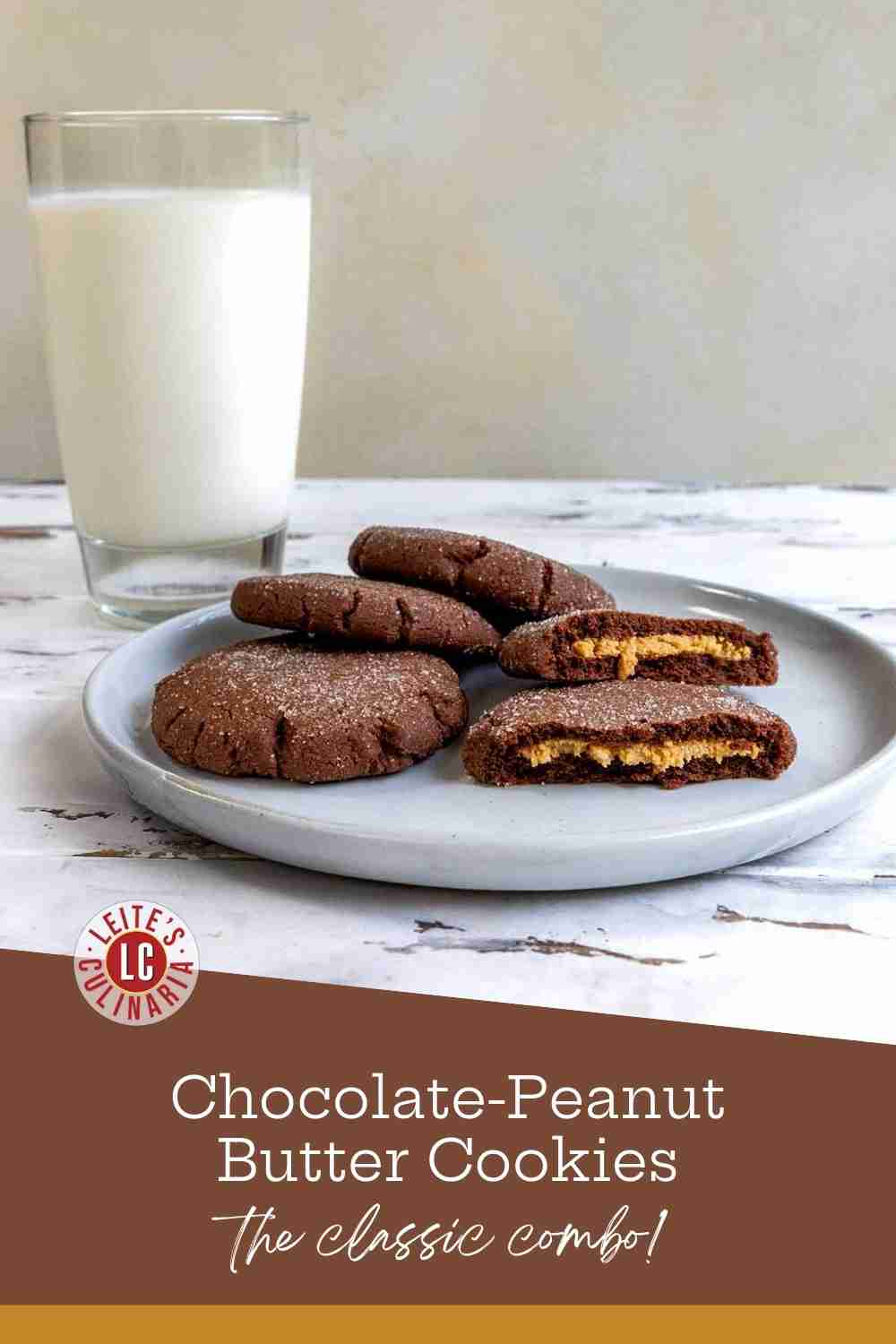 A plate of four sugar-rolled chocolate cookies, with one broken open to show the creamy peanut butter center.