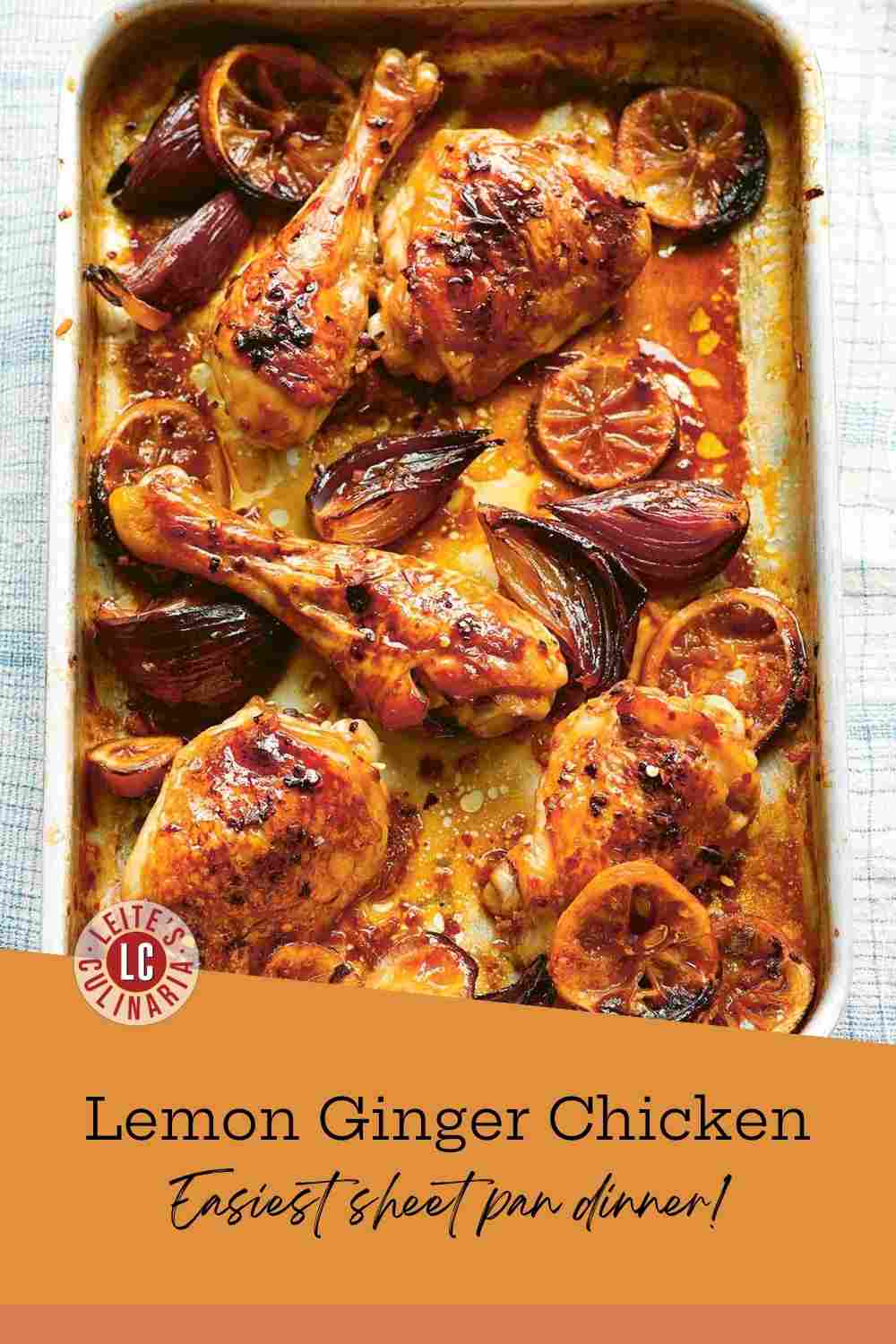 Caramelized chicken thighs and drumsticks with charred lemon slices and red onions in a metal roasting pan.