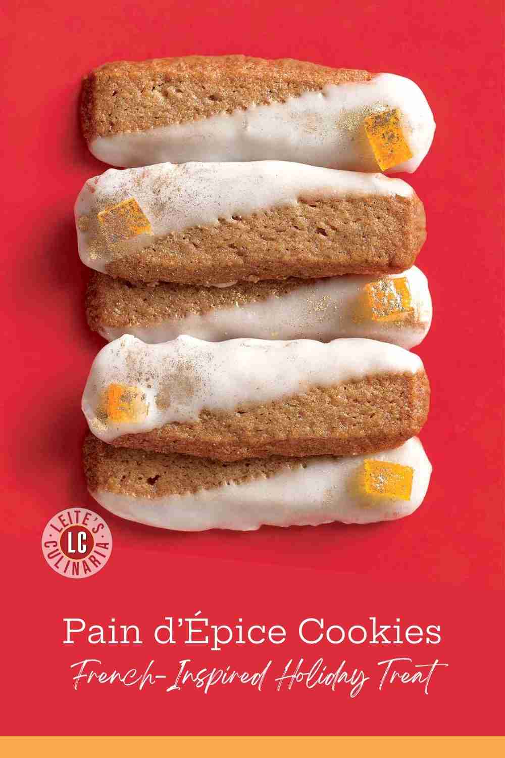 Stack of five glazed spice cookies with candied orange peel and a subtle gold shimmer on a red background.