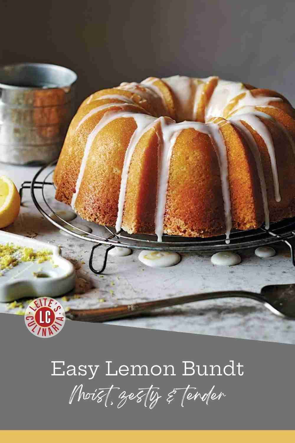 Glazed lemon pound cake on a wire rack with citrus zest and a silver cake server.