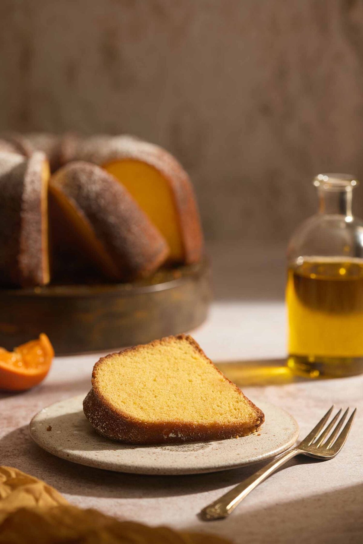 Plated slice of Portuguese orange cake topped with confectioners' sugar.