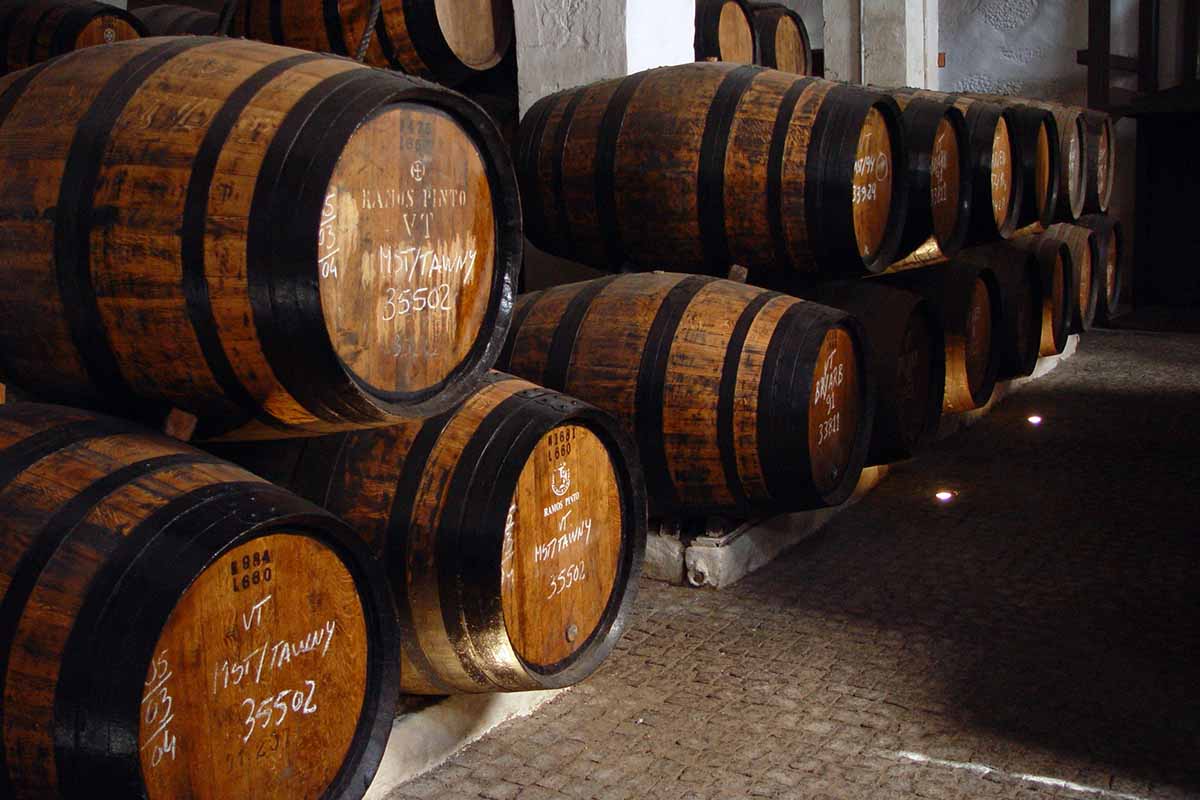 A wine cellar filled with wooden barrels of Ramos Pinto tawny port wine.