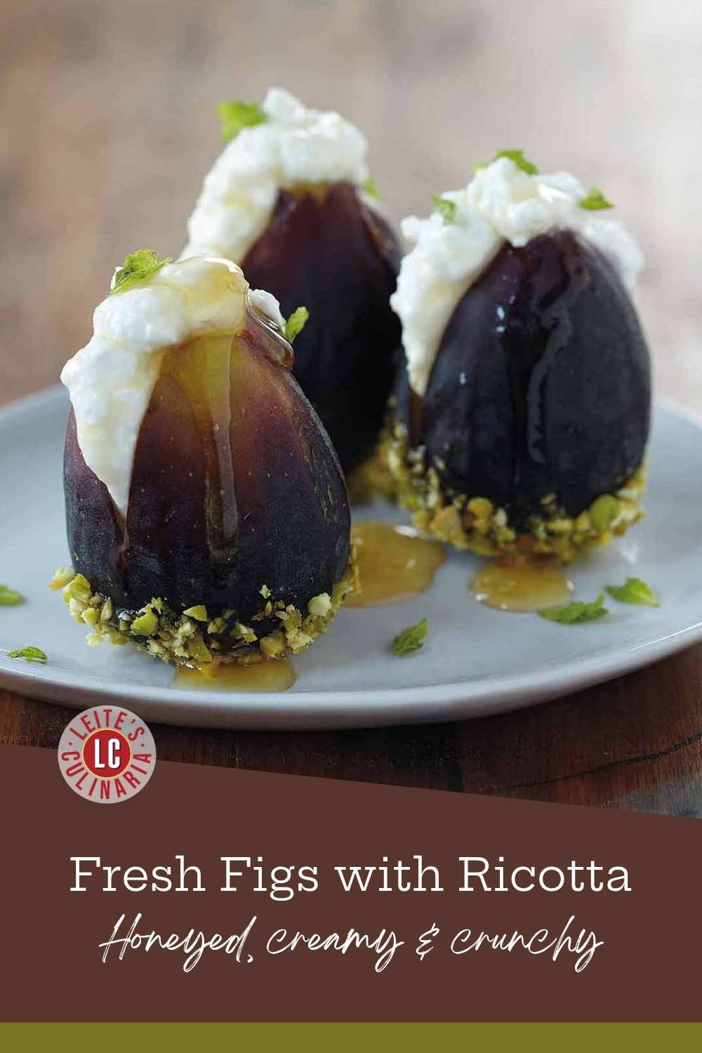 Three fresh figs split and filled with ricotta, drizzled with honey, bases crusted in chopped pistachios.