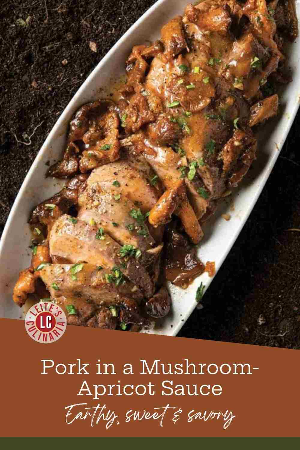 Sliced pork tenderloin and golden chanterelles in glossy sauce on a white oval platter set on dark soil.
