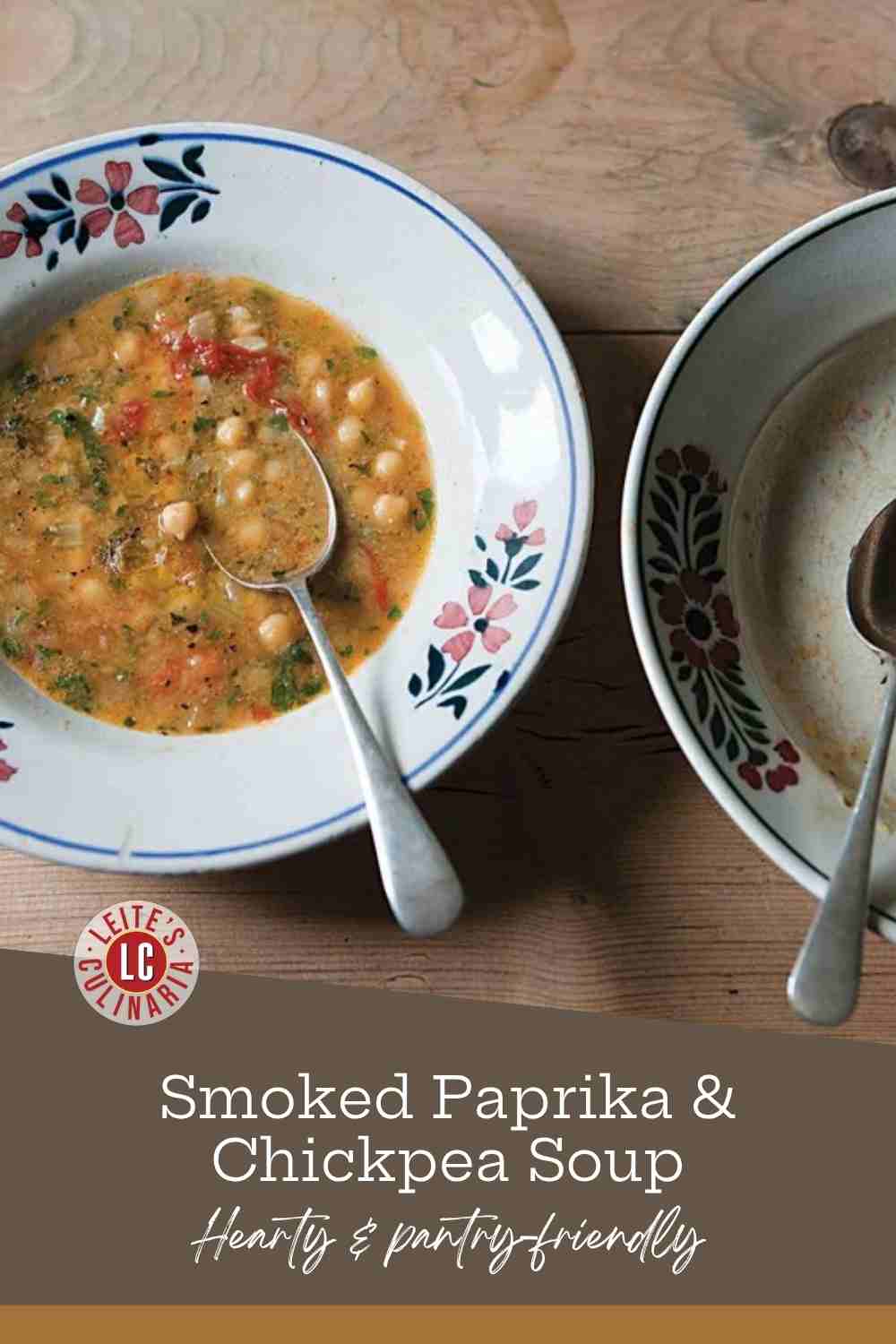 A bowl of smoked paprika and chickpea soup with a spoon resting in it, beside an empty bowl. Text reads Smoked Paprika & Chickpea Soup, Hearty & pantry-friendly.