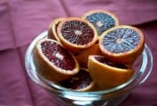 Blood oranges cut in half and piled on a glass cake stand