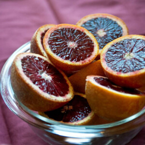 Blood oranges cut in half and piled on a glass cake stand