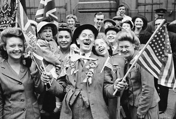 A black and white photo of people celebrating in the streets after WWII.