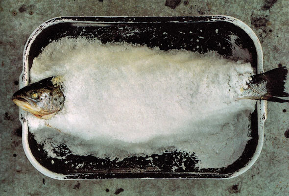 A whole salt-baked wild salmon in a metal baking dish.