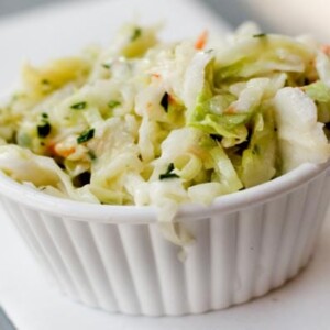 Small white ramekin filled with coleslaw with maple syrup